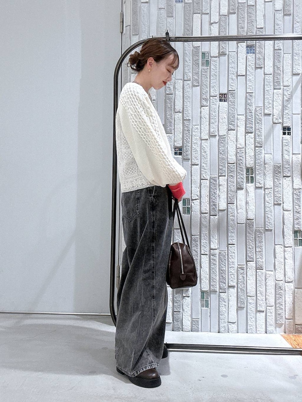 グレー系のTシャツ/カットソー、ブラウン系のサンダル、グレー系のデニムパンツを着用したレディースの冬コーディネートの3枚目の写真