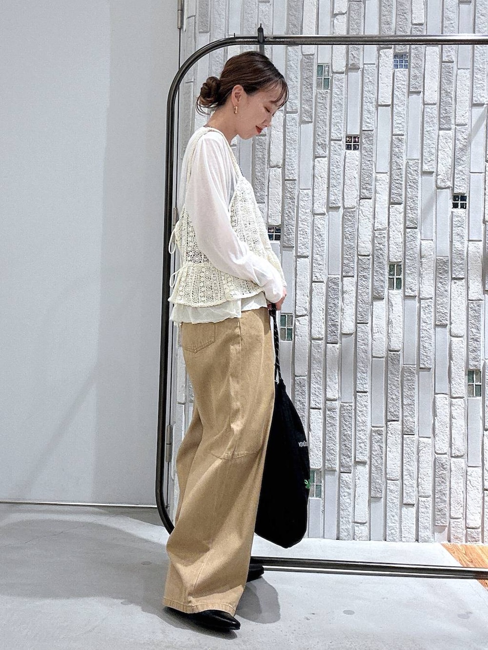 ホワイト系のTシャツ/カットソー、ベージュ系のその他パンツ、ブラック系のトートバッグを着用したレディースの春コーディネートの3枚目の写真