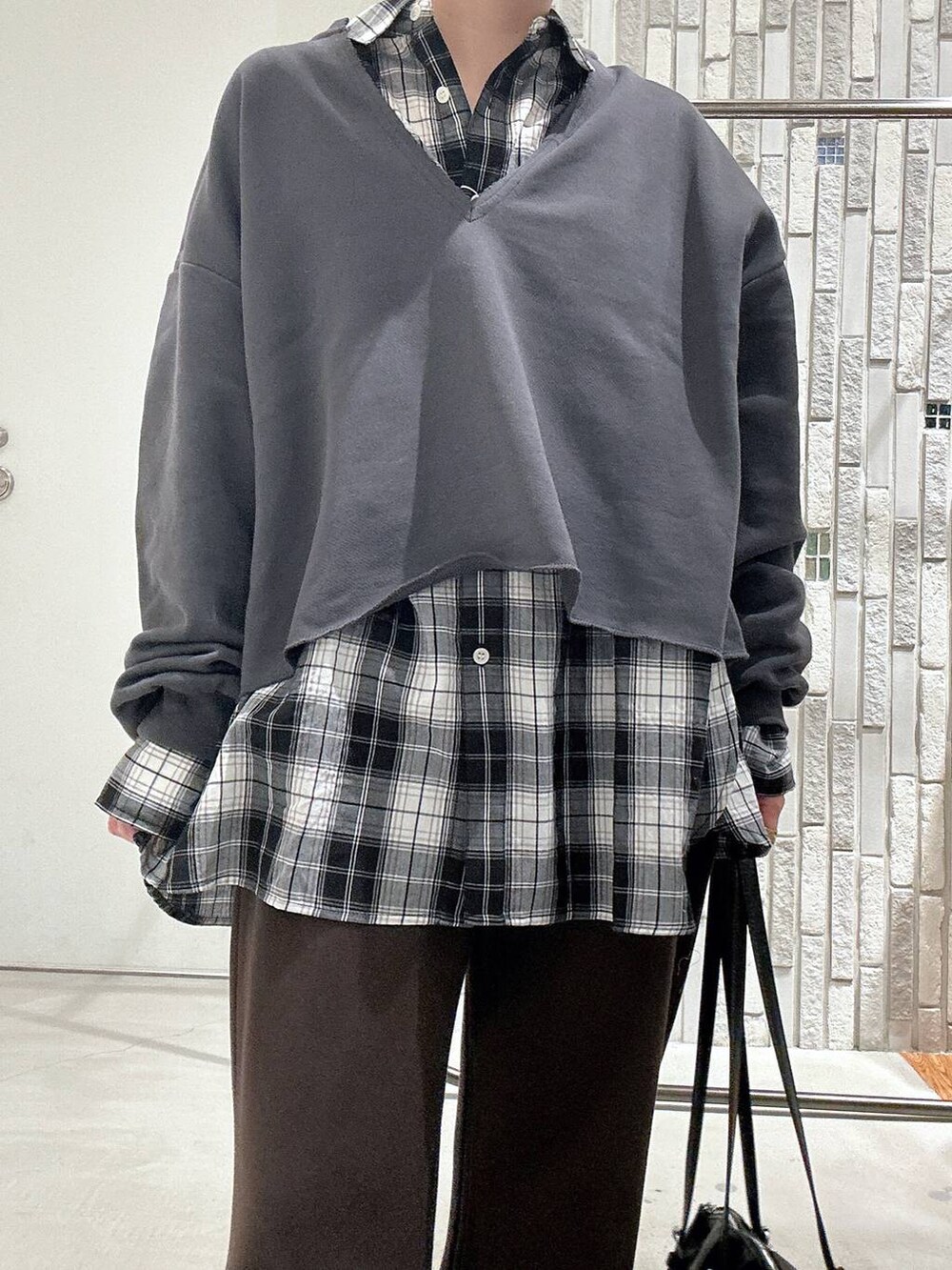 ブラック系のボストンバッグ、ブラック系のその他シューズ、グレー系のTシャツ/カットソーを着用したレディースの冬コーディネートの4枚目の写真