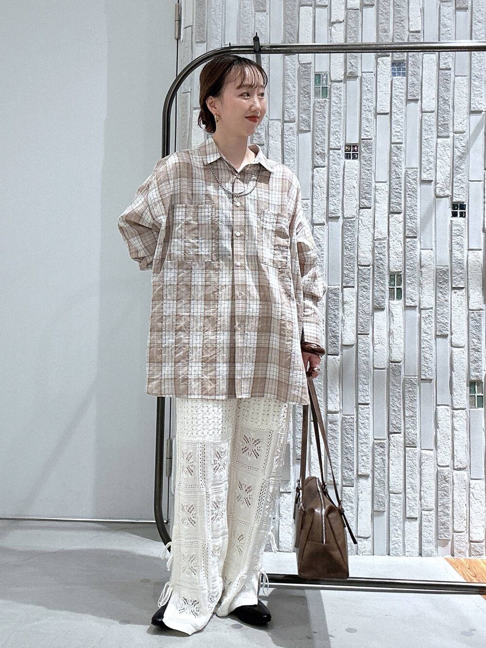 ブラウン系のボストンバッグ、ホワイト系のその他パンツ、ブラック系のパンプスを着用したレディースの春コーディネートの3枚目の写真