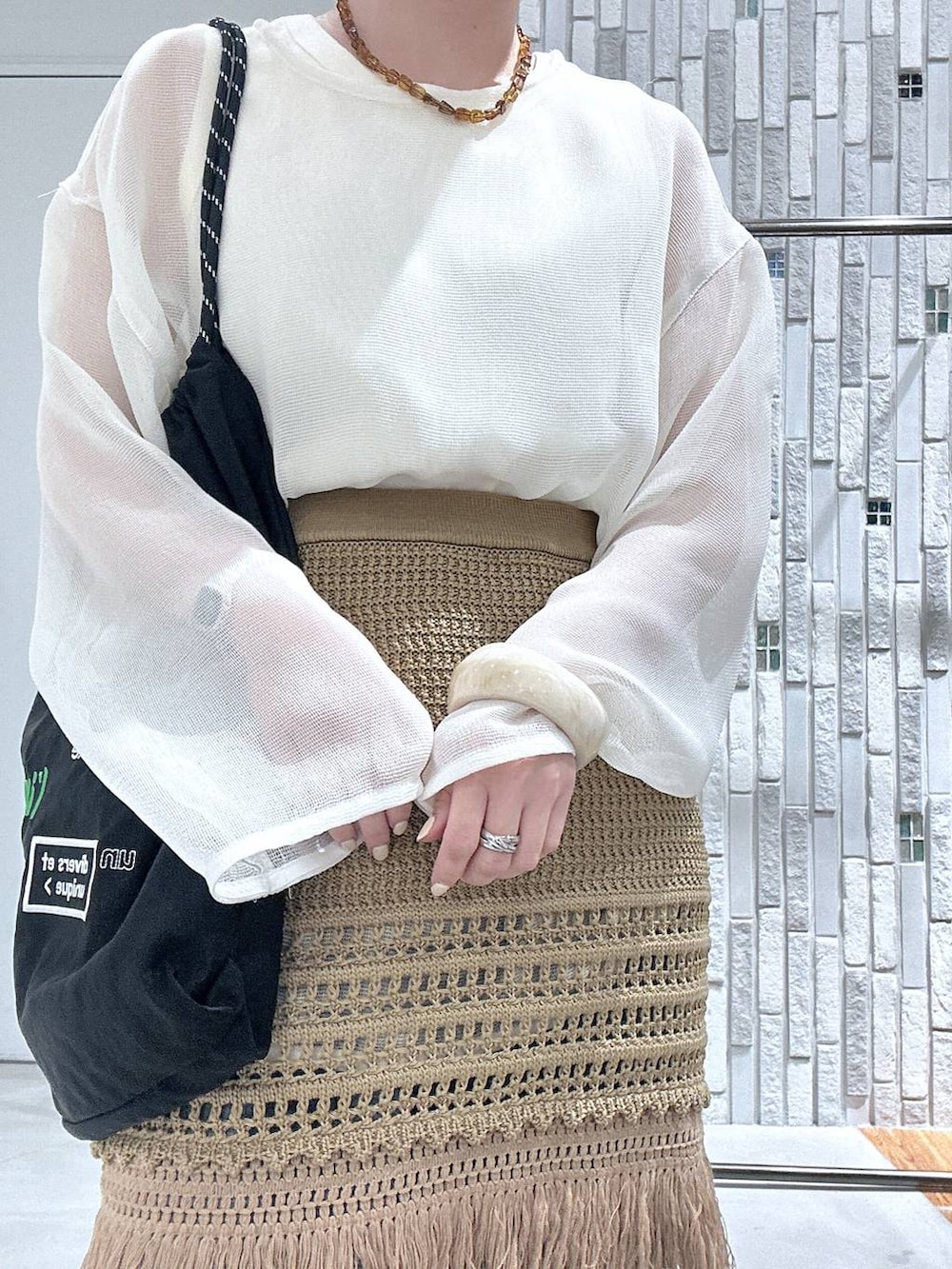 ブルー系のデニムパンツ、ブラック系のトートバッグ、ブラック系のパンプスを着用したレディースの春コーディネートの5枚目の写真