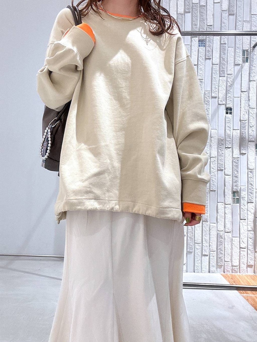 ブラック系のサンダル、ホワイト系のスカート、ブラウン系のボストンバッグを着用したレディースの冬コーディネートの5枚目の写真