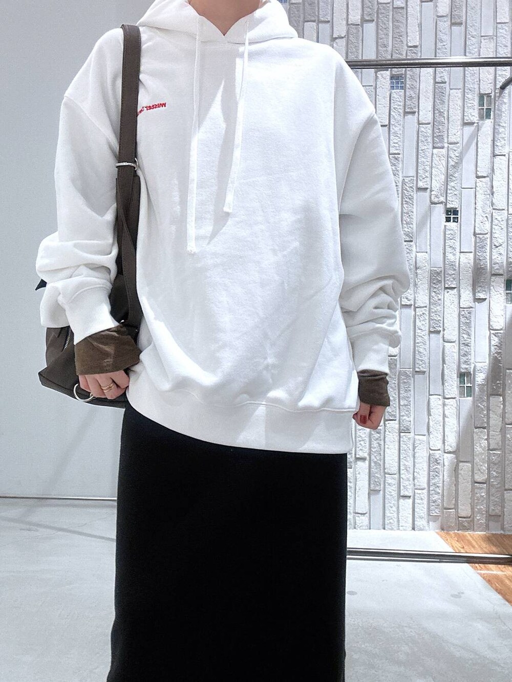 ブラック系のスカート、ブラウン系のTシャツ/カットソー、ブラウン系のショルダーバッグを着用したレディースの冬コーディネートの5枚目の写真