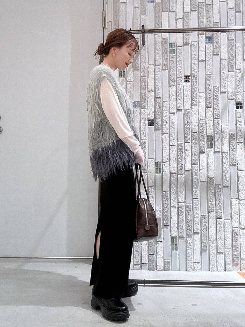 ホワイト系のTシャツ/カットソー、ブラック系のスカート、ブラック系のブーツを着用したレディースの冬コーディネートの3枚目の写真