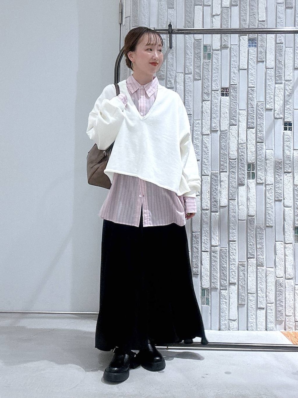 ブラック系のサンダル、ブラウン系のボストンバッグ、ピンク系のシャツ/ブラウスを着用したレディースの冬コーディネートの3枚目の写真