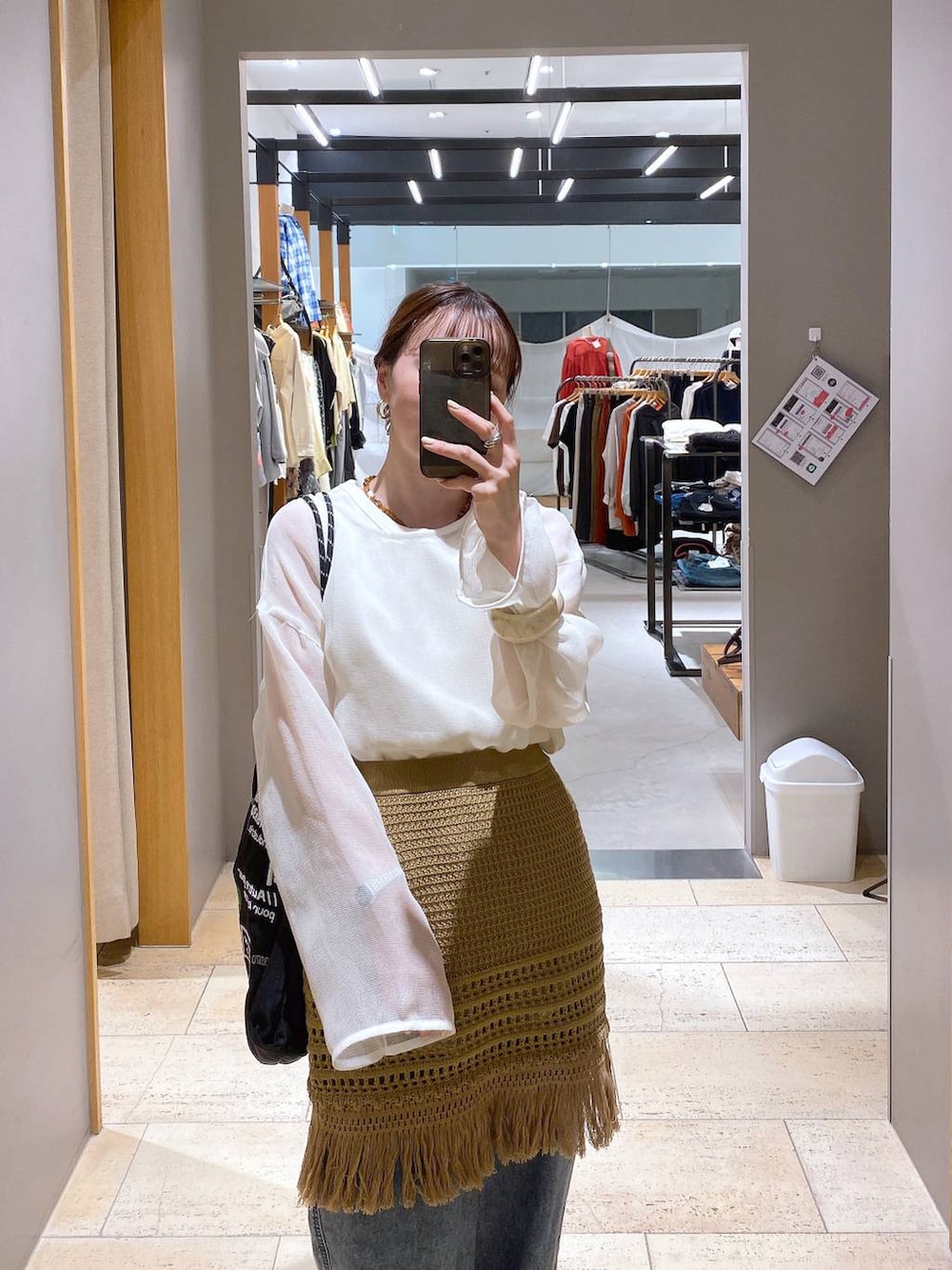 ブルー系のデニムパンツ、ブラック系のトートバッグ、ブラック系のパンプスを着用したレディースの春コーディネートの6枚目の写真