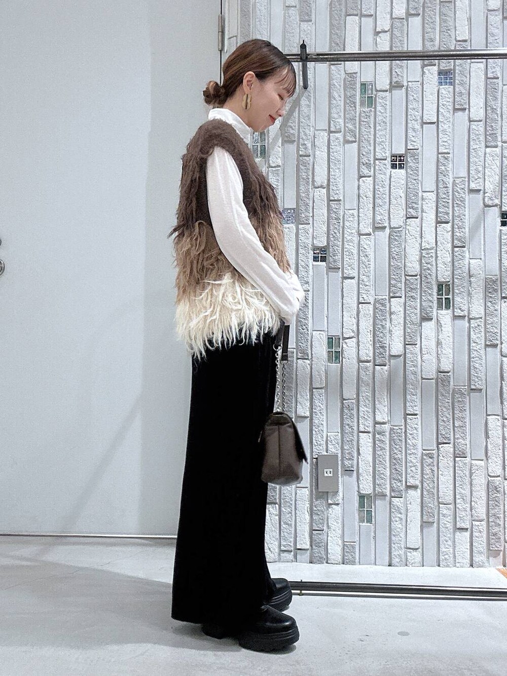 ホワイト系のTシャツ/カットソー、ブラック系のブーツ、ブラック系のスカートを着用したレディースの冬コーディネートの4枚目の写真