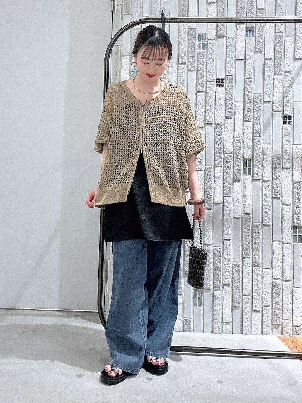 ブルー系のデニムパンツ、その他のショルダーバッグ、ブラック系のキャミソールを着用したレディースの春コーディネートの2枚目の写真