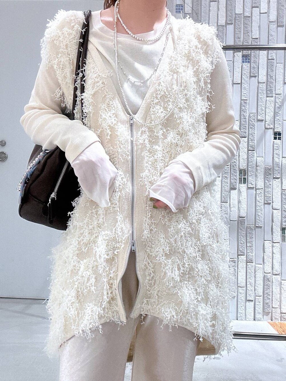 ホワイト系のTシャツ/カットソー、ブラウン系のボストンバッグ、ホワイト系のその他パンツを着用したレディースの春コーディネートの5枚目の写真