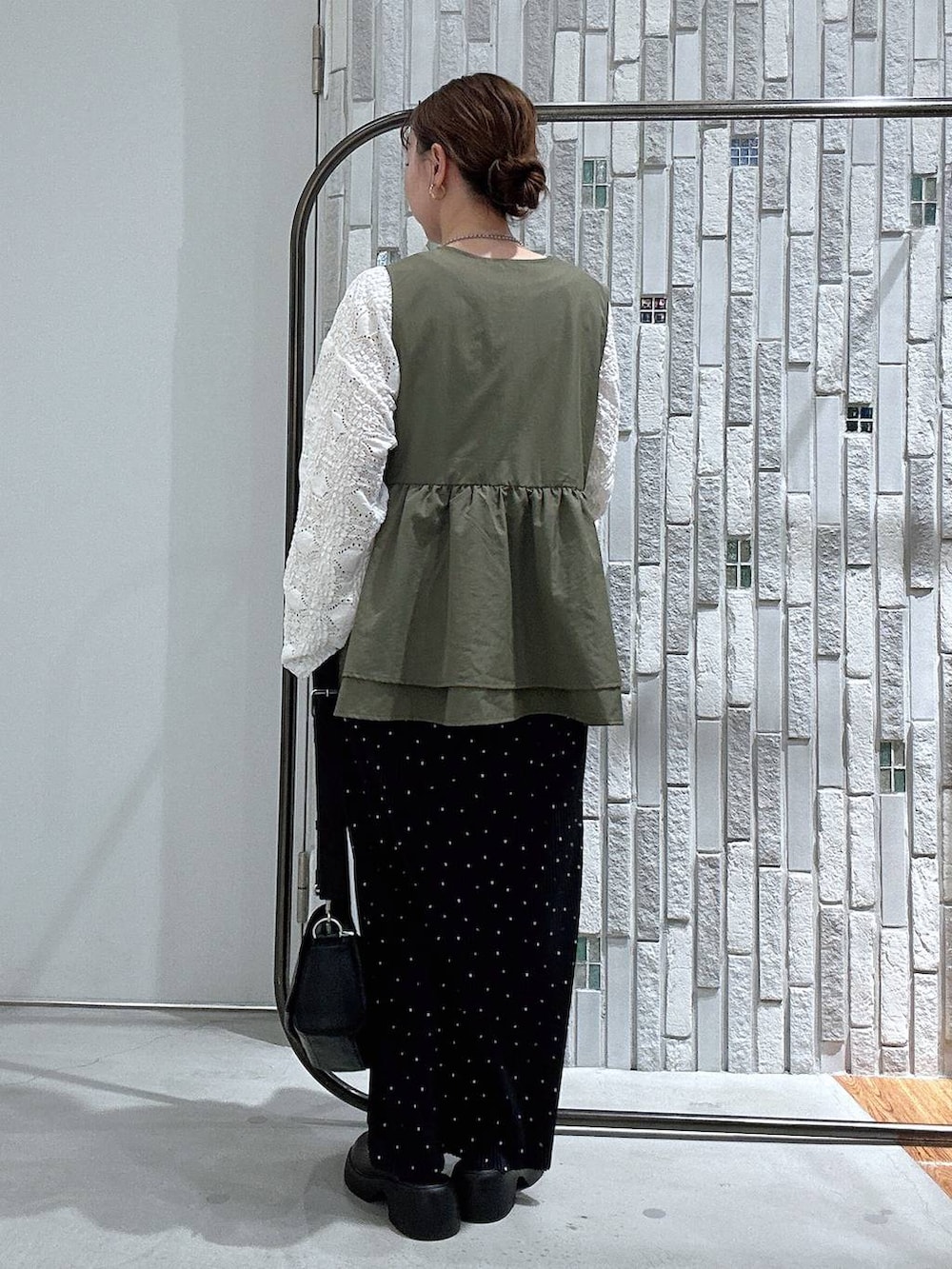 ブラック系のショルダーバッグ、ブラウン系のサンダル、ホワイト系のTシャツ/カットソーを着用したレディースの春コーディネートの4枚目の写真