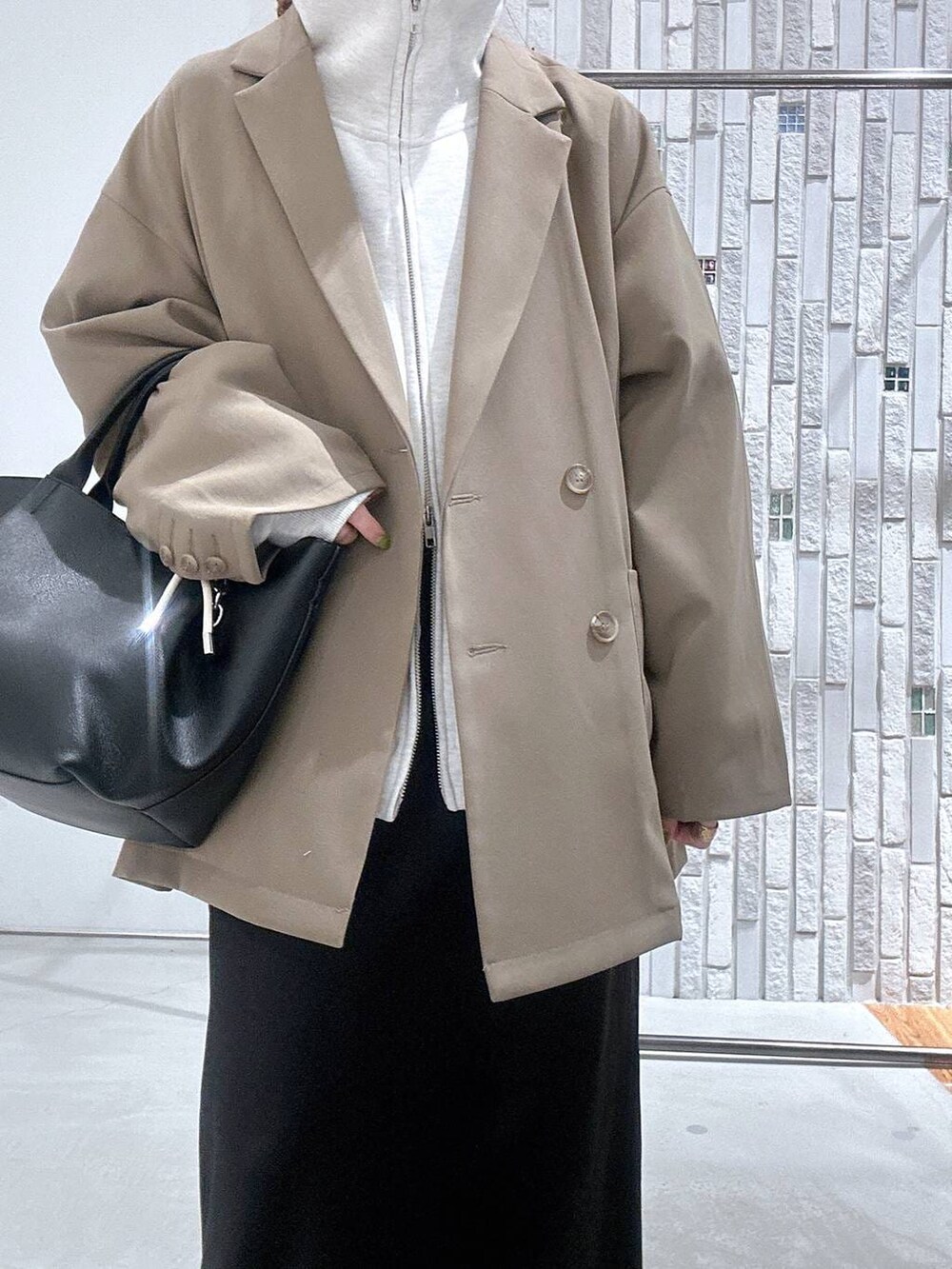 ブラック系のスカート、ブラウン系のテーラードジャケット、ブラック系のトートバッグを着用したレディースの冬コーディネートの5枚目の写真