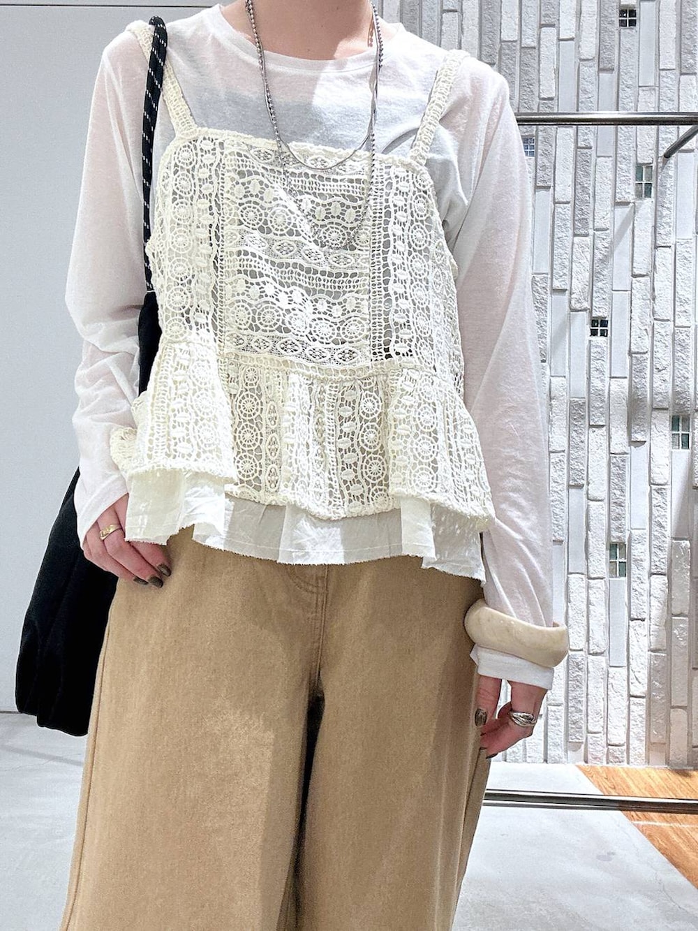 ホワイト系のTシャツ/カットソー、ベージュ系のその他パンツ、ブラック系のトートバッグを着用したレディースの春コーディネートの4枚目の写真