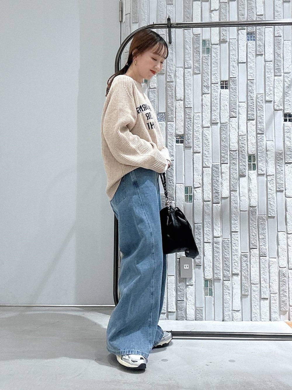 ブラック系のショルダーバッグ、グレー系のその他アウター、ブルー系のデニムパンツを着用したレディースの冬コーディネートの6枚目の写真