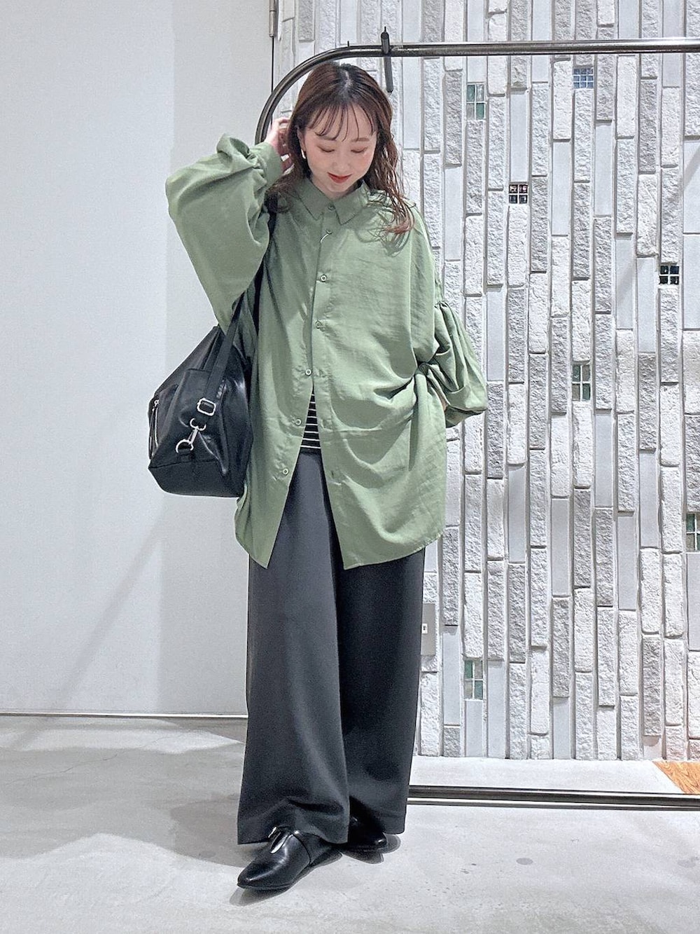 ブラック系のショルダーバッグ、グリーン系のシャツ/ブラウス、ブラック系のTシャツ/カットソーを着用したレディースの春コーディネートの2枚目の写真