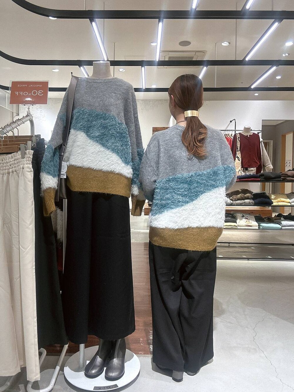 ブラック系のその他パンツ、その他のブーツ、グレー系のニット/セーターを着用したレディースの冬コーディネートの4枚目の写真