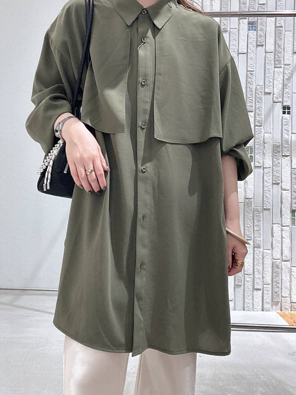 グリーン系のシャツ/ブラウス、ブラック系のボストンバッグ、ホワイト系のその他パンツを着用したレディースの春コーディネートの5枚目の写真