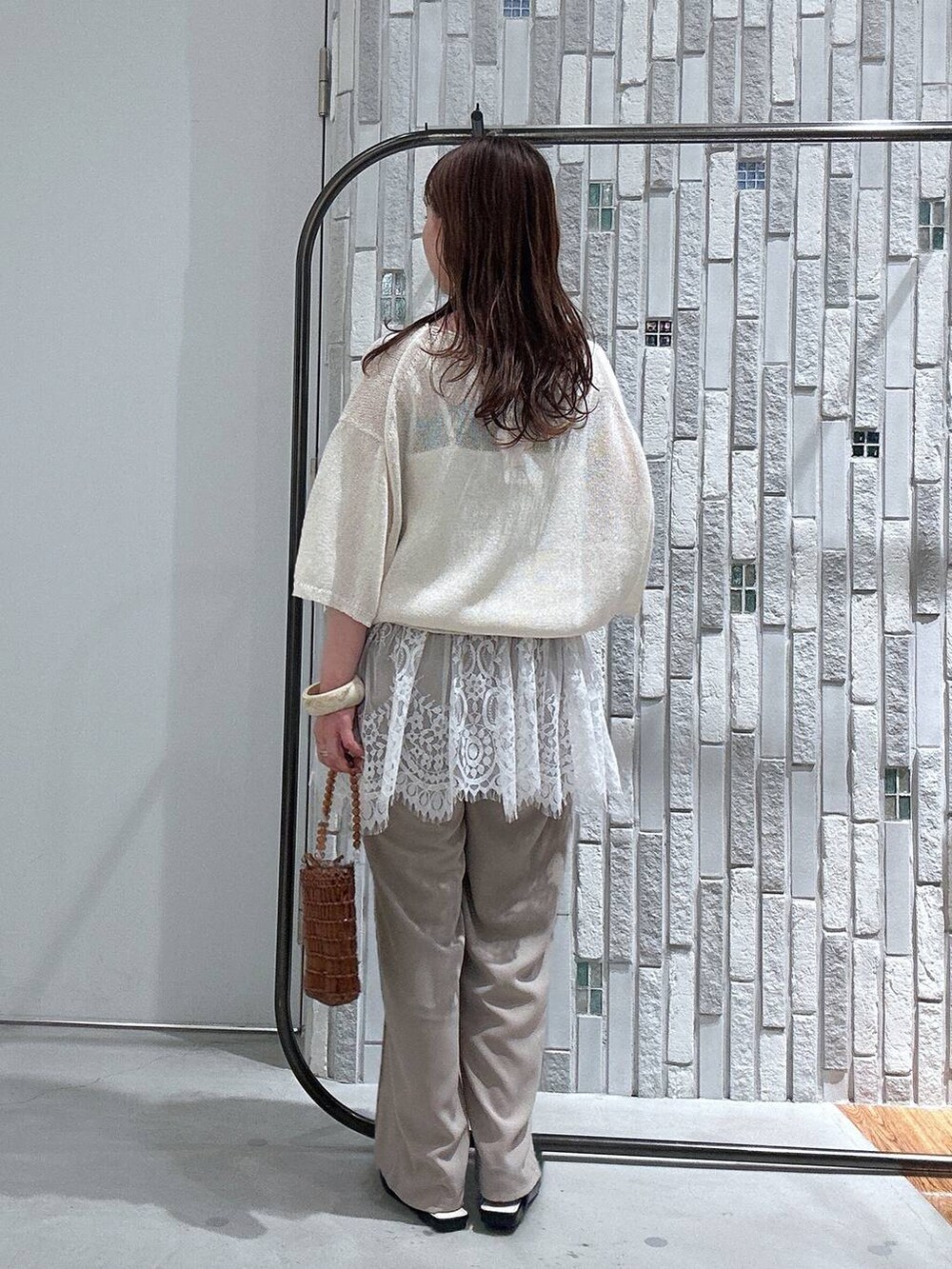 ホワイト系のニット/セーター、ベージュ系のその他パンツ、ブラック系のパンプスを着用したレディースの春コーディネートの4枚目の写真