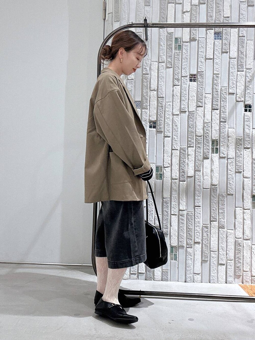 ブラウン系のテーラードジャケット、ブラック系のボストンバッグ、ブラック系のTシャツ/カットソーを着用したレディースの春コーディネートの4枚目の写真