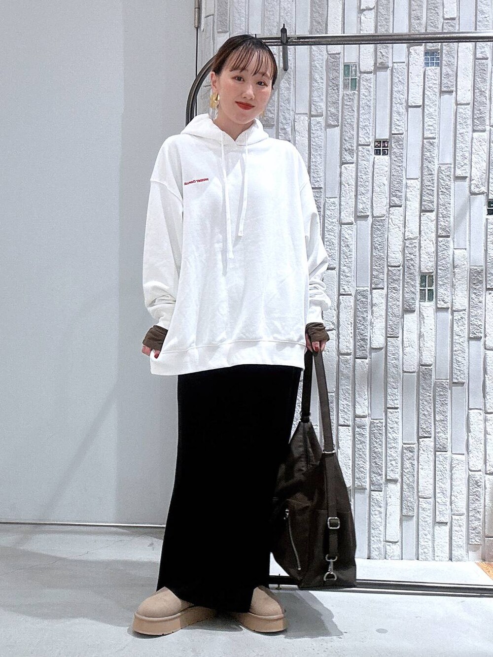 ブラック系のスカート、ブラウン系のTシャツ/カットソー、ブラウン系のショルダーバッグを着用したレディースの冬コーディネートの2枚目の写真