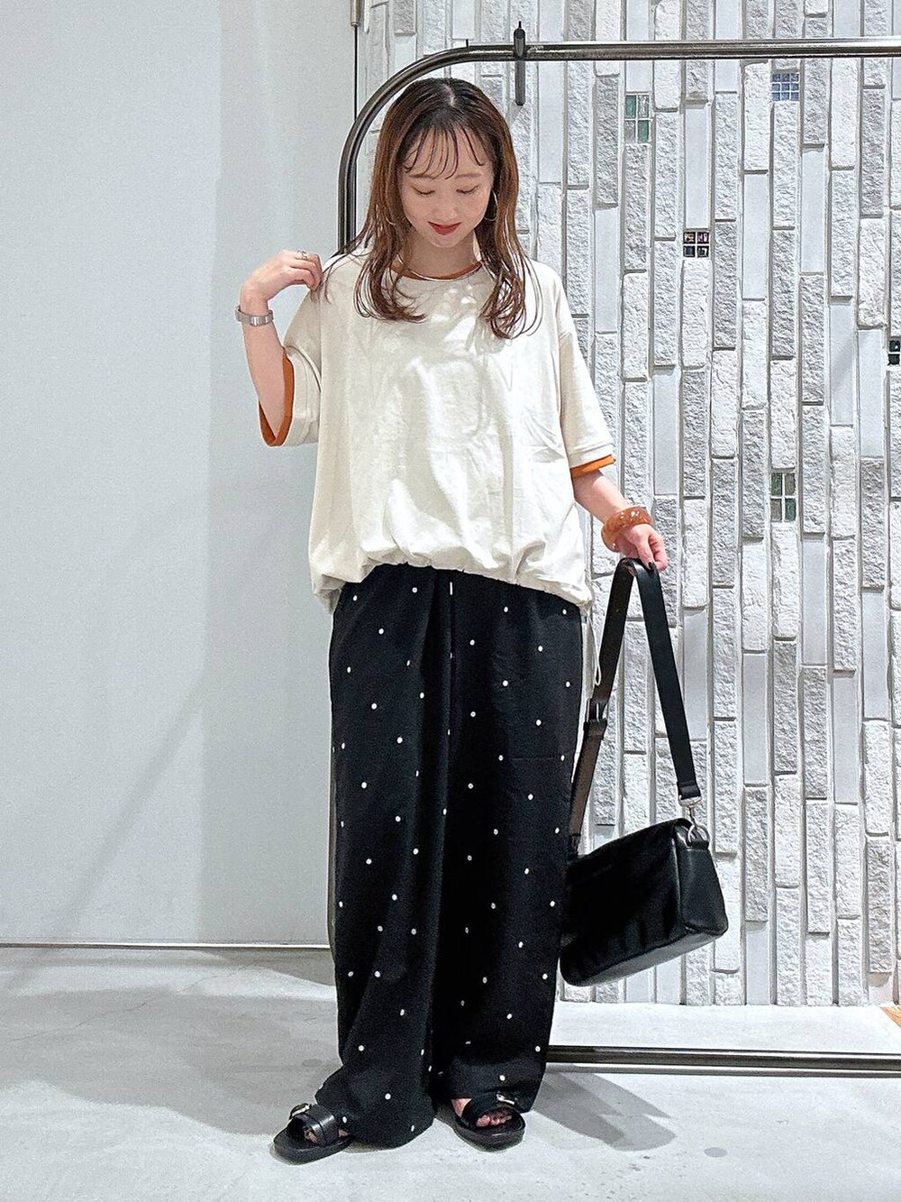 ベージュ系のTシャツ/カットソー、ブラック系のショルダーバッグ、ブラック系のその他パンツを着用したレディースの夏コーディネートの2枚目の写真
