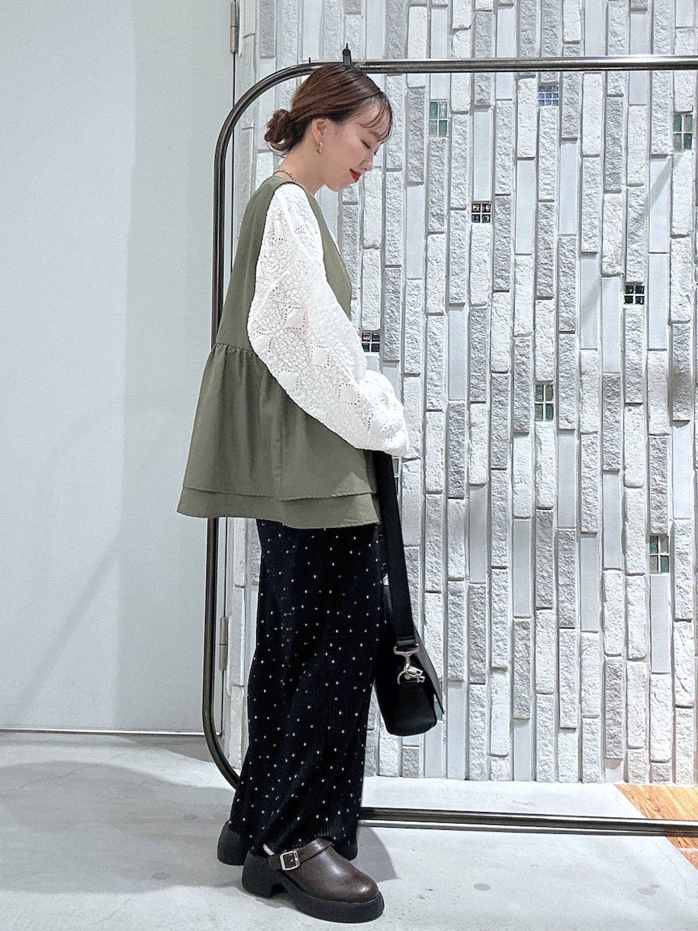 ブラック系のショルダーバッグ、ブラウン系のサンダル、ホワイト系のTシャツ/カットソーを着用したレディースの春コーディネートの3枚目の写真