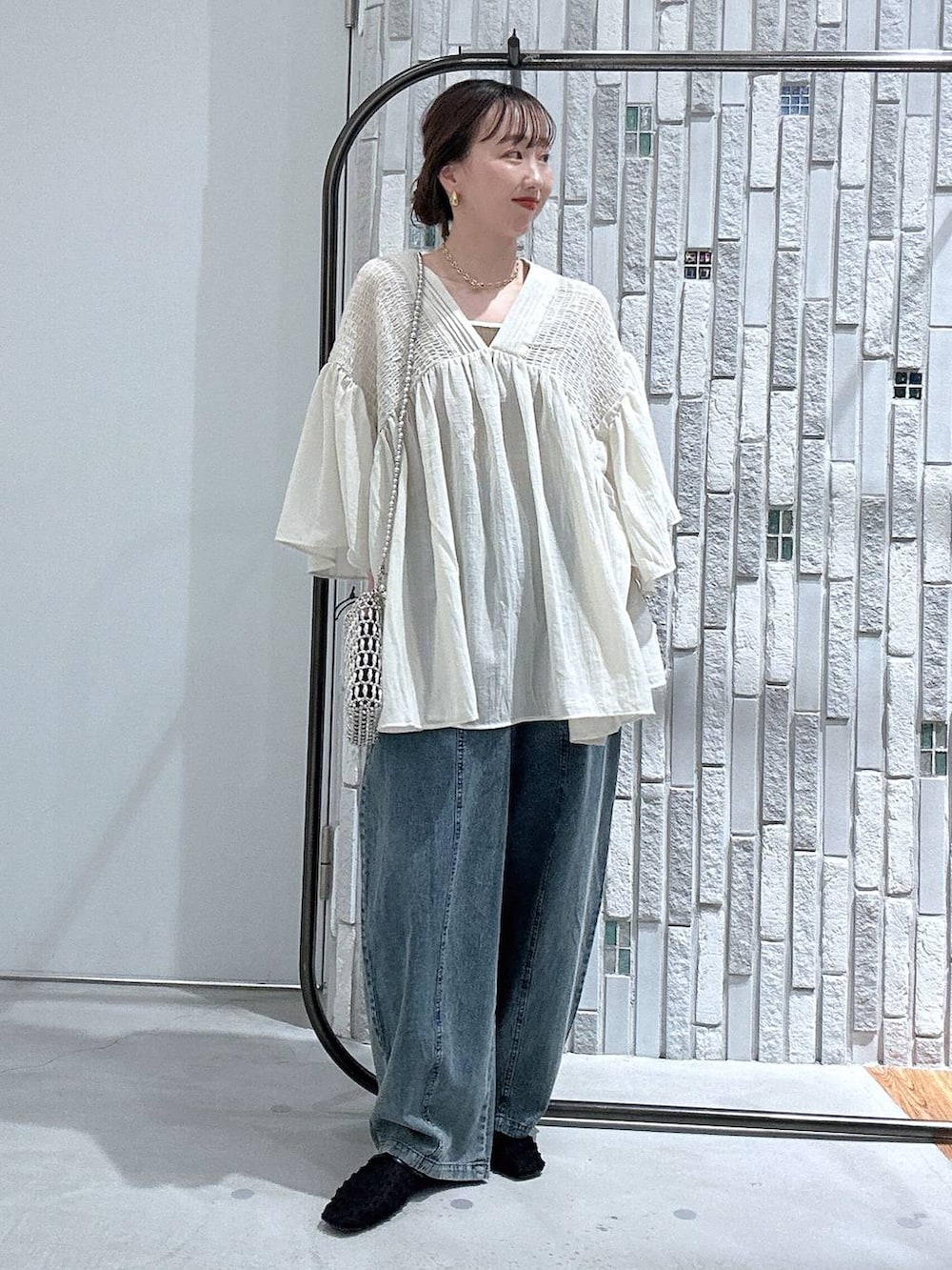 ベージュ系のシャツ/ブラウス、シルバー系のショルダーバッグ、ブラック系のパンプスを着用したレディースの春コーディネートの2枚目の写真
