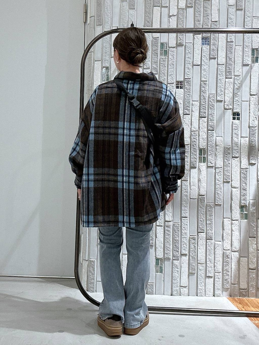 ブルー系のデニムパンツ、ブラック系のボディバッグ/ウエストポーチ、ブラウン系のシャツ/ブラウスを着用したレディースの秋コーディネートの3枚目の写真