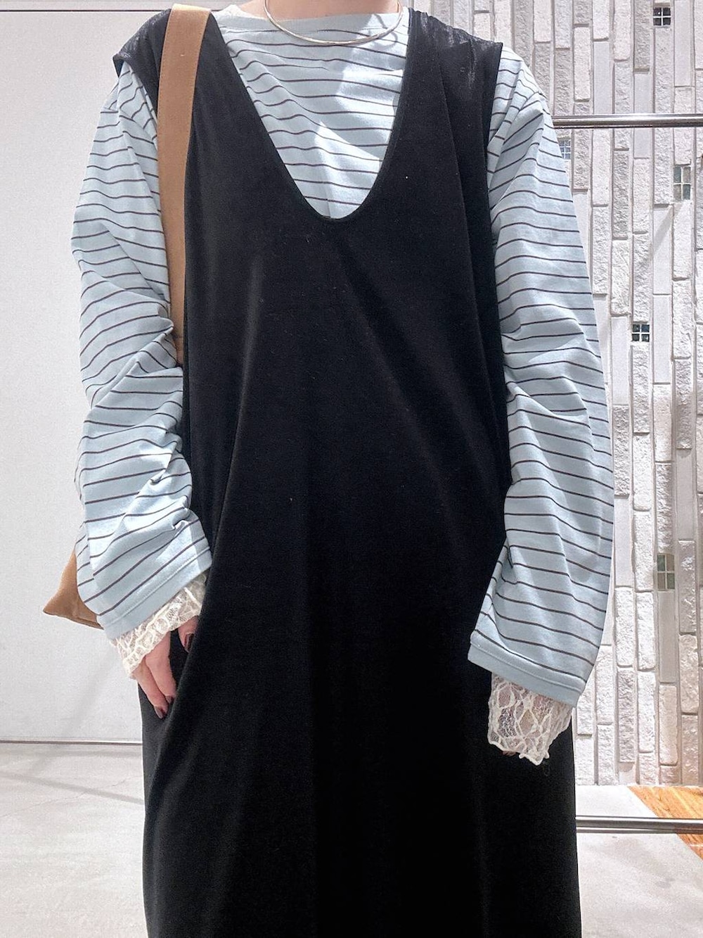 ブラウン系のショルダーバッグ、グリーン系のTシャツ/カットソー、ブラック系のその他シューズを着用したレディースの冬コーディネートの5枚目の写真