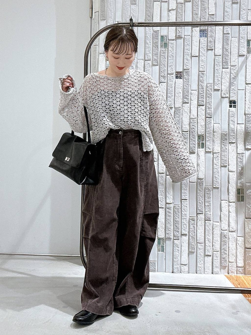 ブラウン系のその他パンツ、ブラック系のトートバッグ、ブラック系のローファーを着用したレディースの秋コーディネートの2枚目の写真