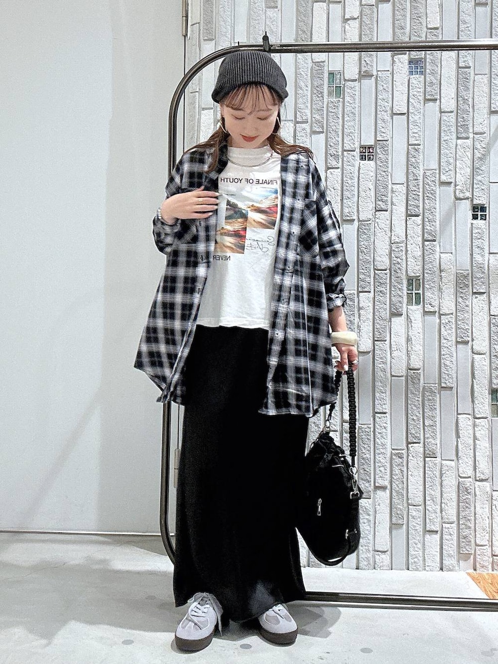 ブルー系のスニーカー、ブラック系のスカート、ホワイト系のTシャツ/カットソーを着用したレディースの夏コーディネートの2枚目の写真