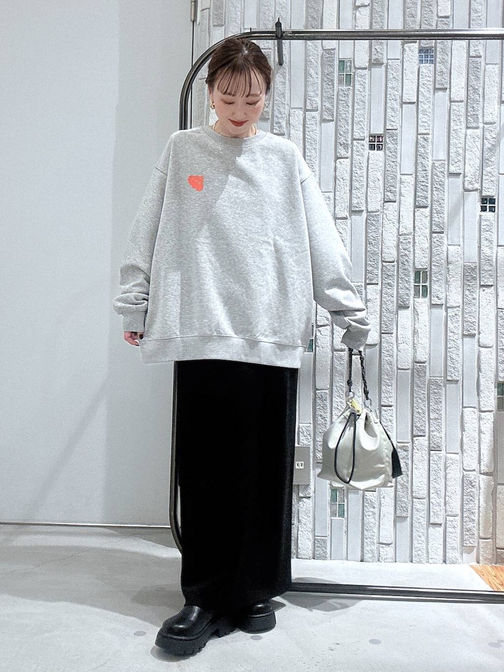 グレー系のショルダーバッグ、ブラック系のスカート、グレー系のスウェットを着用したレディースの冬コーディネートの6枚目の写真