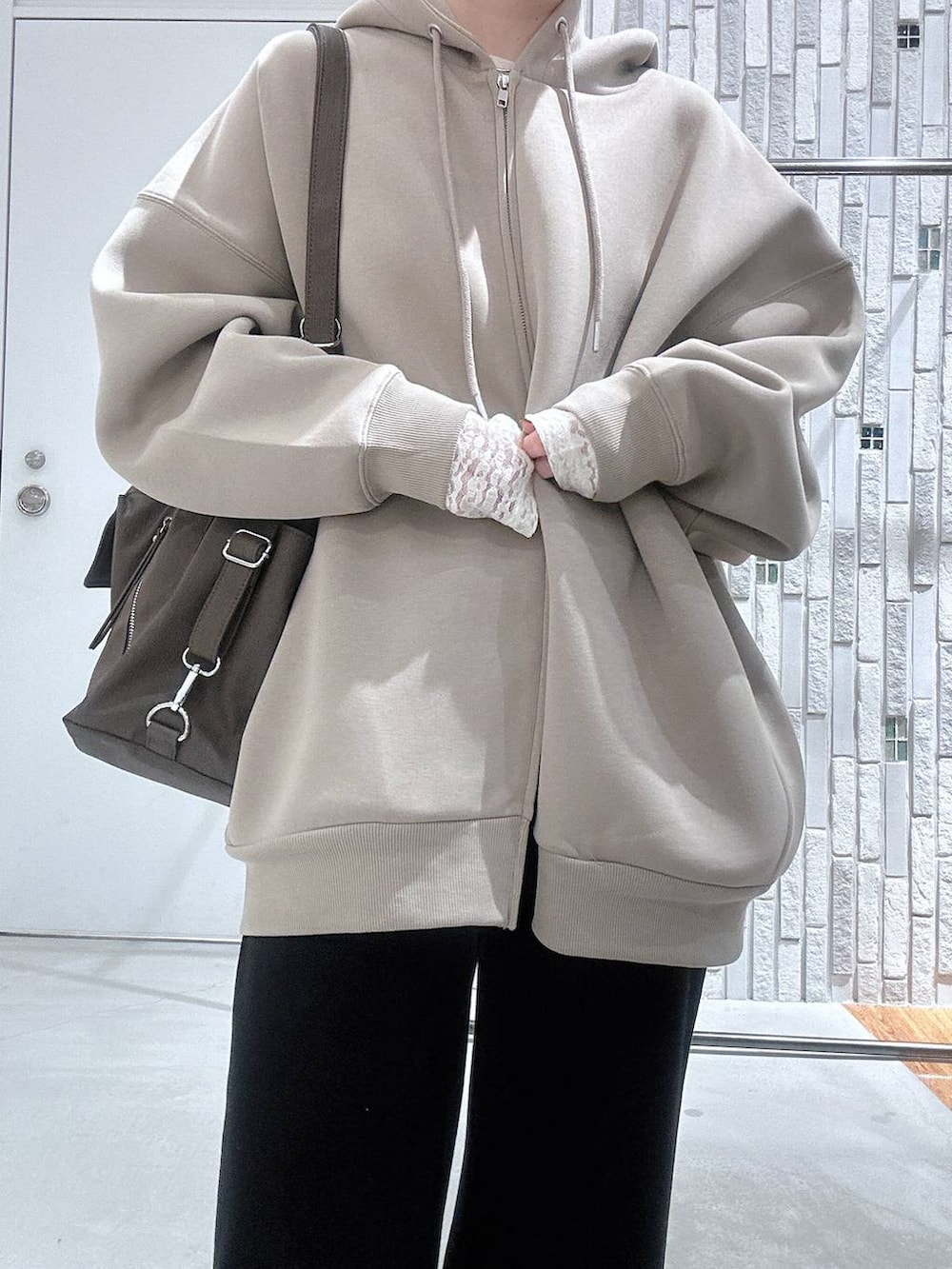 ホワイト系のTシャツ/カットソー、ベージュ系のパーカー、ブラック系のブーツを着用したレディースの冬コーディネートの4枚目の写真