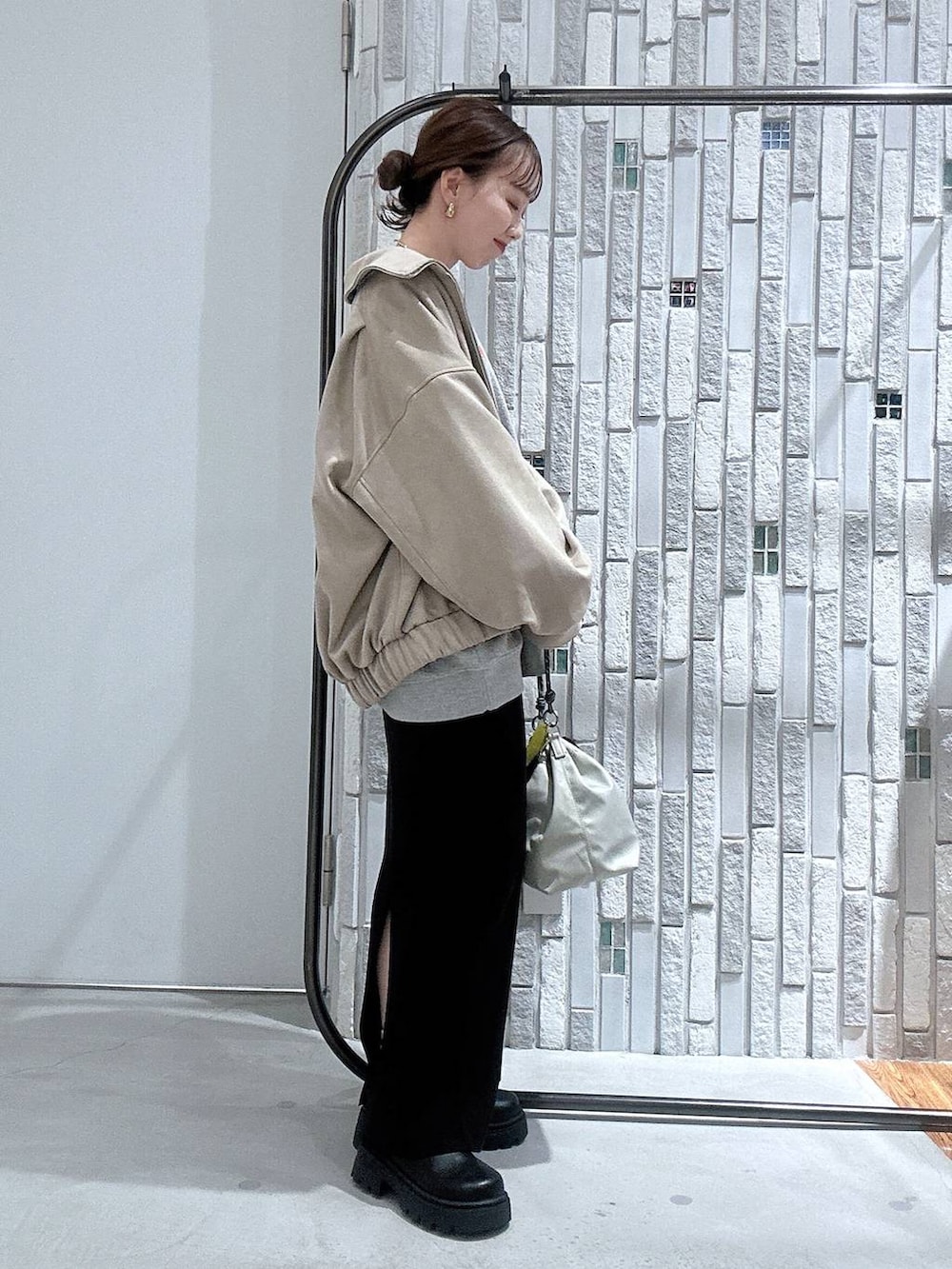 グレー系のショルダーバッグ、ブラック系のスカート、グレー系のスウェットを着用したレディースの冬コーディネートの3枚目の写真