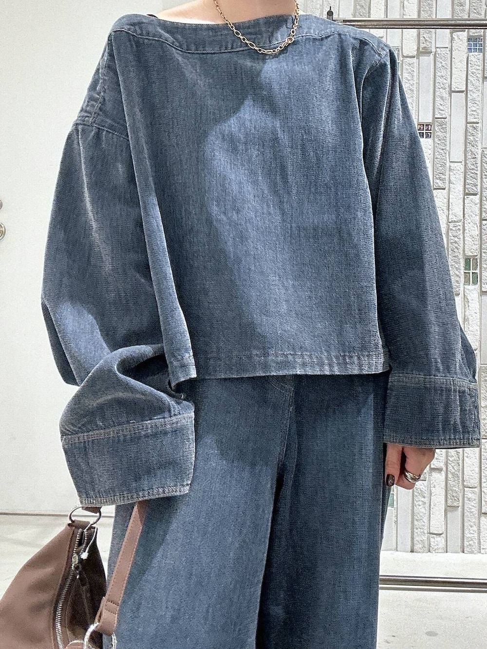 ブラック系のローファー、ブルー系のデニムパンツ、ブルー系のTシャツ/カットソーを着用したレディースの秋コーディネートの6枚目の写真