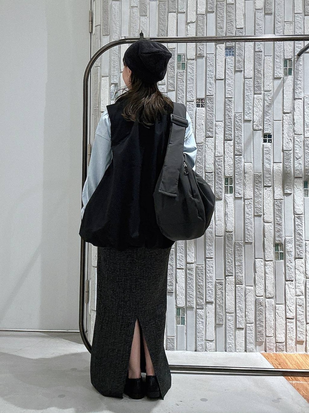 ブルー系のTシャツ/カットソー、グレー系のショルダーバッグ、ブラック系のベストを着用したレディースの秋コーディネートの4枚目の写真