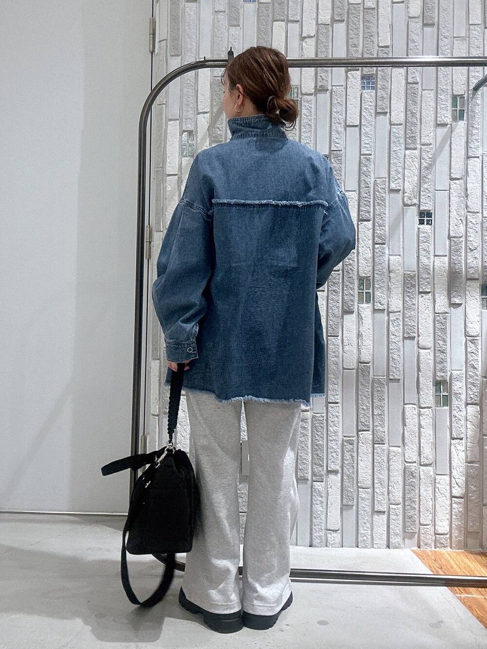 イエロー系のTシャツ/カットソー、ブルー系のシャツ/ブラウス、ブラック系のショルダーバッグを着用したレディースの冬コーディネートの5枚目の写真