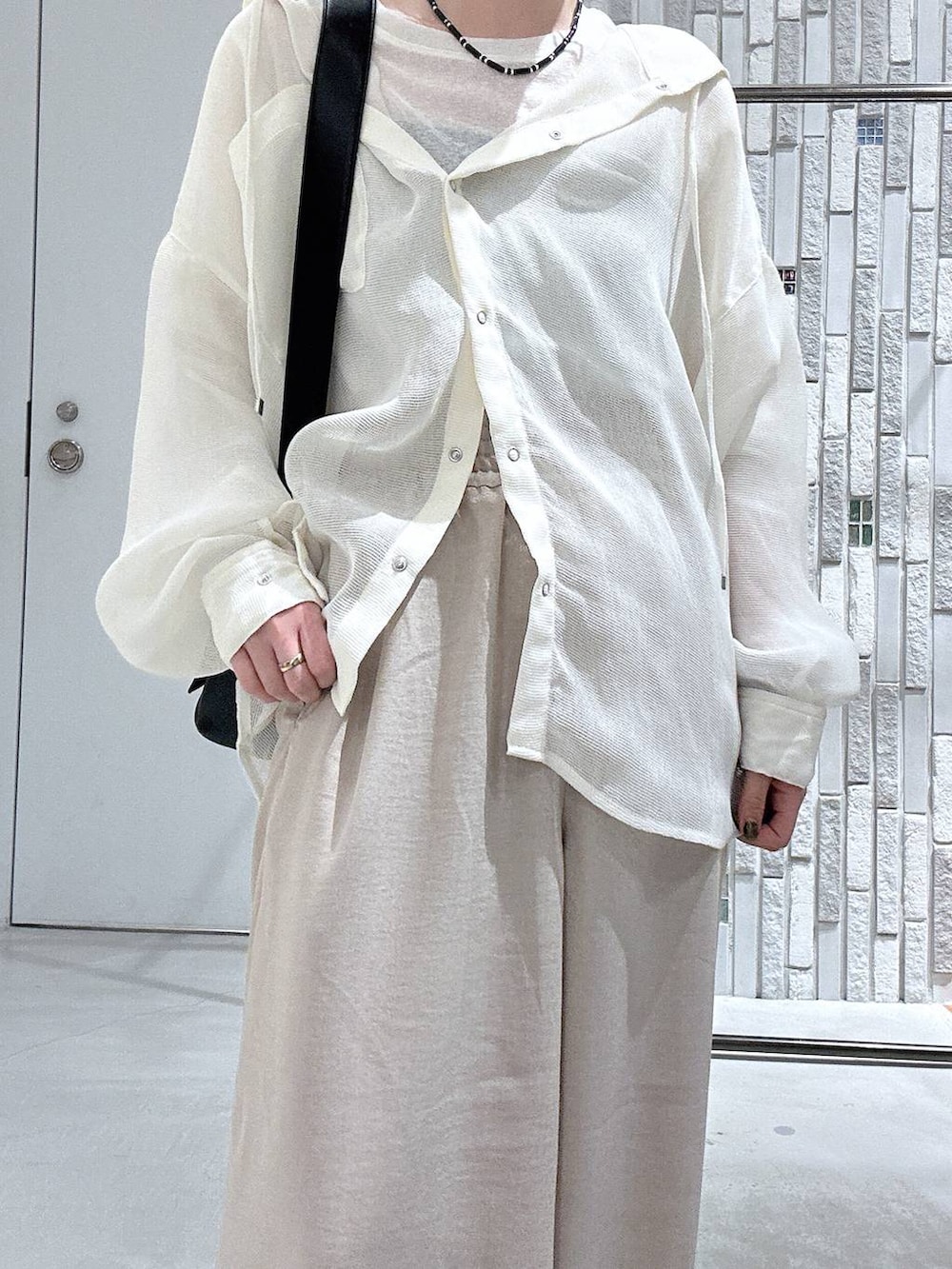 ホワイト系のTシャツ/カットソー、ブラック系のショルダーバッグ、ベージュ系のその他パンツを着用したレディースの春コーディネートの5枚目の写真