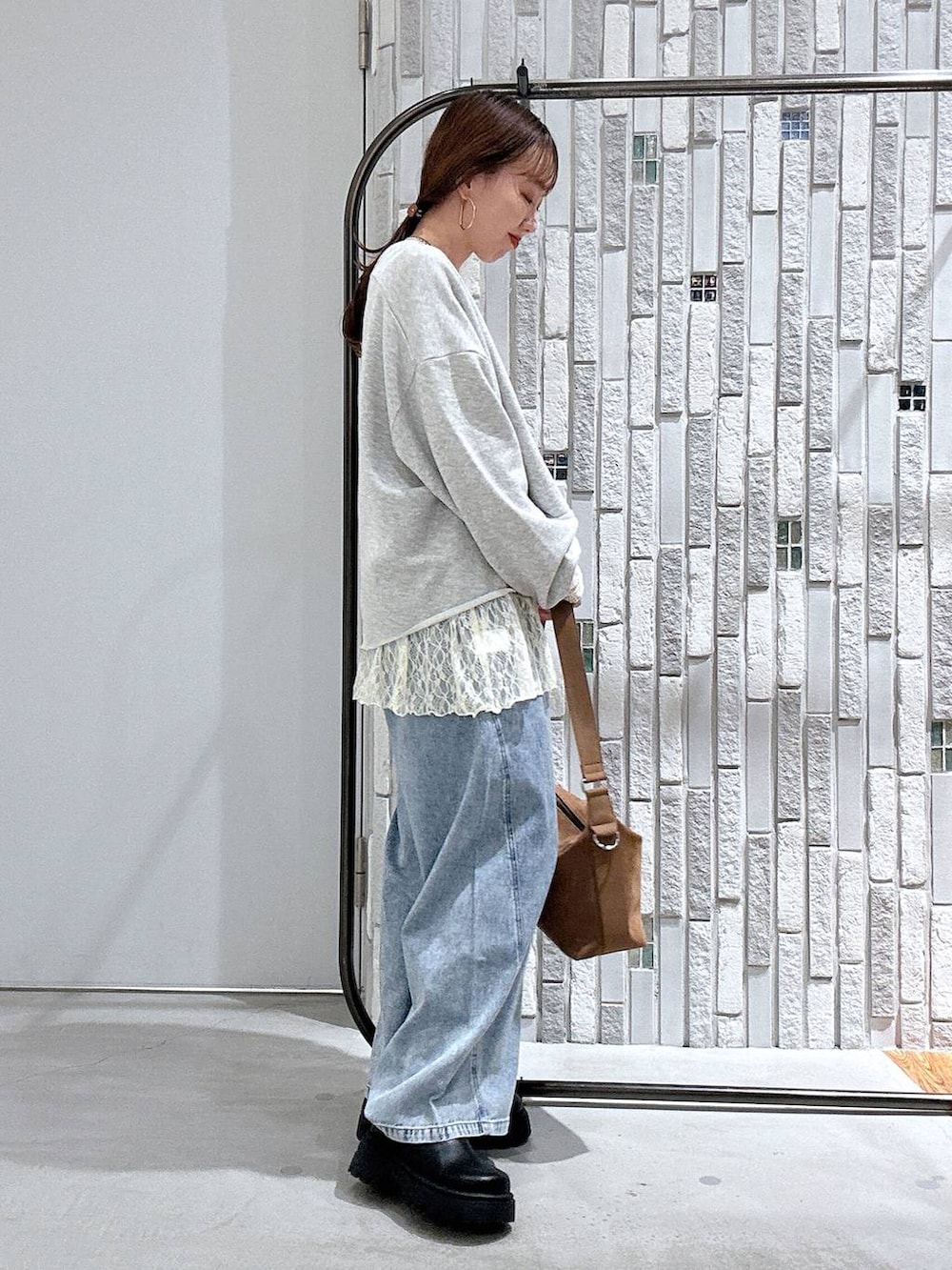 ブラウン系のショルダーバッグ、ブルー系のデニムパンツ、ブラック系のその他シューズを着用したレディースの春コーディネートの3枚目の写真