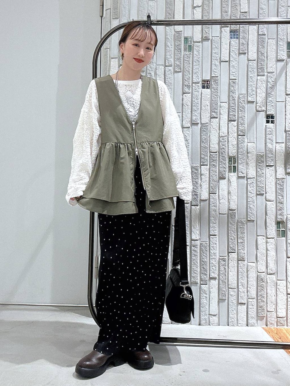 ブラック系のショルダーバッグ、ブラウン系のサンダル、ホワイト系のTシャツ/カットソーを着用したレディースの春コーディネートの2枚目の写真