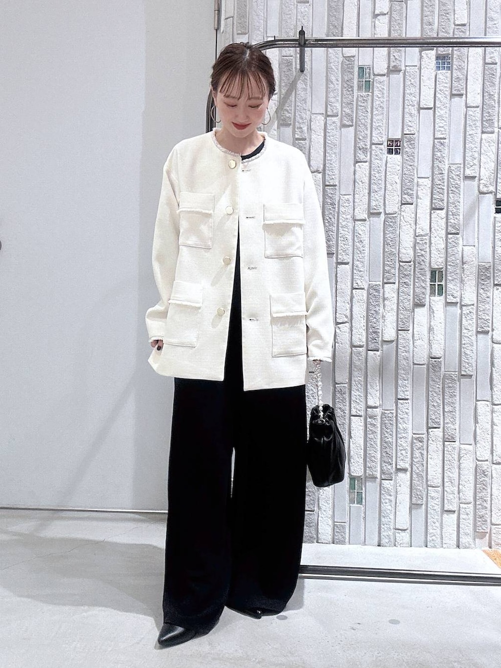 ホワイト系のノーカラージャケット、ブルー系のサロペット/オーバーオール、ブラック系のショルダーバッグを着用したレディースの冬コーディネートの2枚目の写真