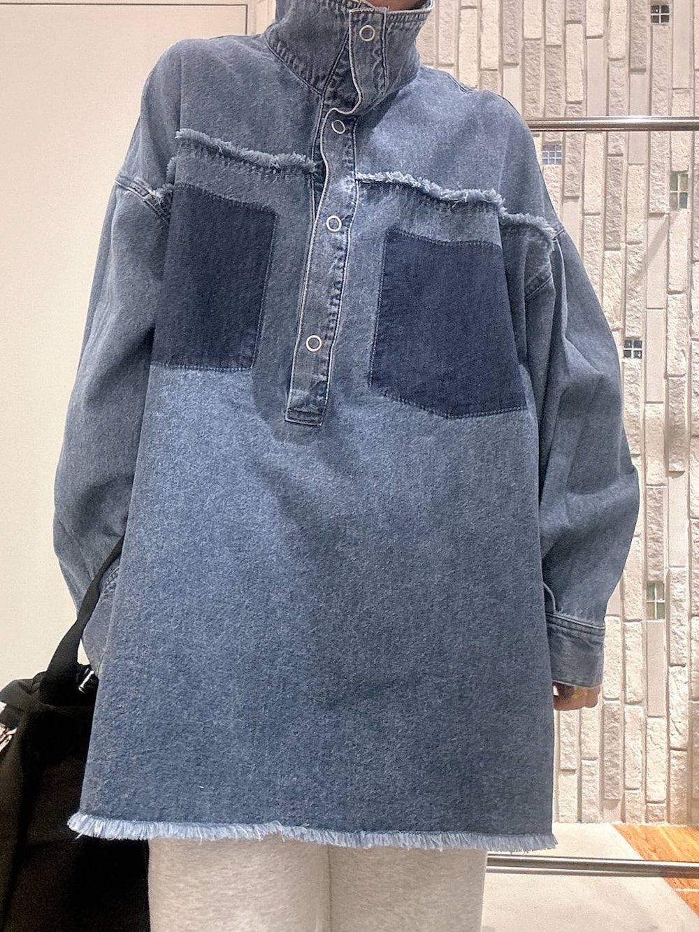 イエロー系のTシャツ/カットソー、ブルー系のシャツ/ブラウス、ブラック系のショルダーバッグを着用したレディースの冬コーディネートの6枚目の写真