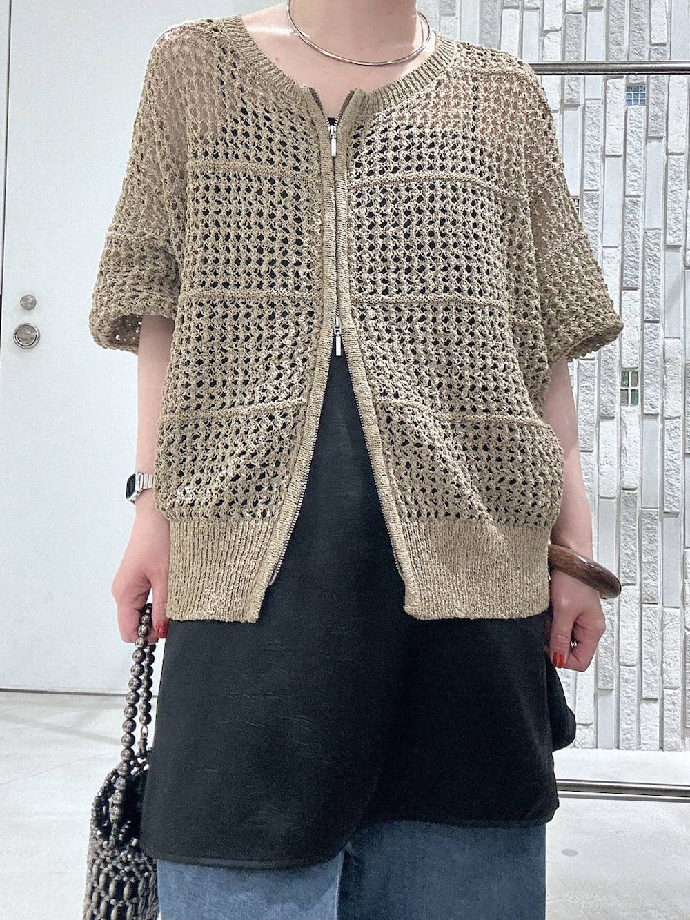ブルー系のデニムパンツ、その他のショルダーバッグ、ブラック系のキャミソールを着用したレディースの春コーディネートの5枚目の写真