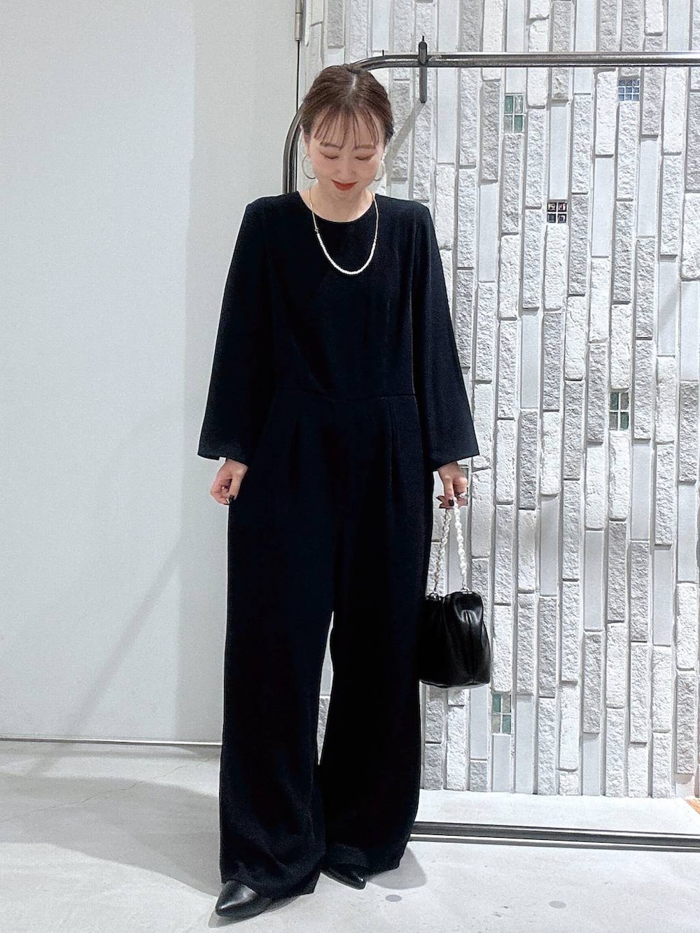 ホワイト系のノーカラージャケット、ブルー系のサロペット/オーバーオール、ブラック系のショルダーバッグを着用したレディースの冬コーディネートの6枚目の写真