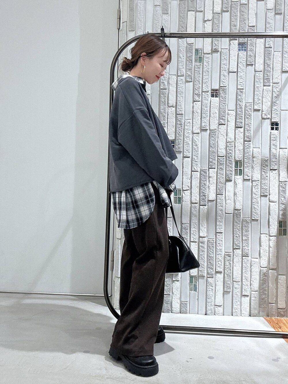 ブラック系のボストンバッグ、ブラック系のその他シューズ、グレー系のTシャツ/カットソーを着用したレディースの冬コーディネートの2枚目の写真