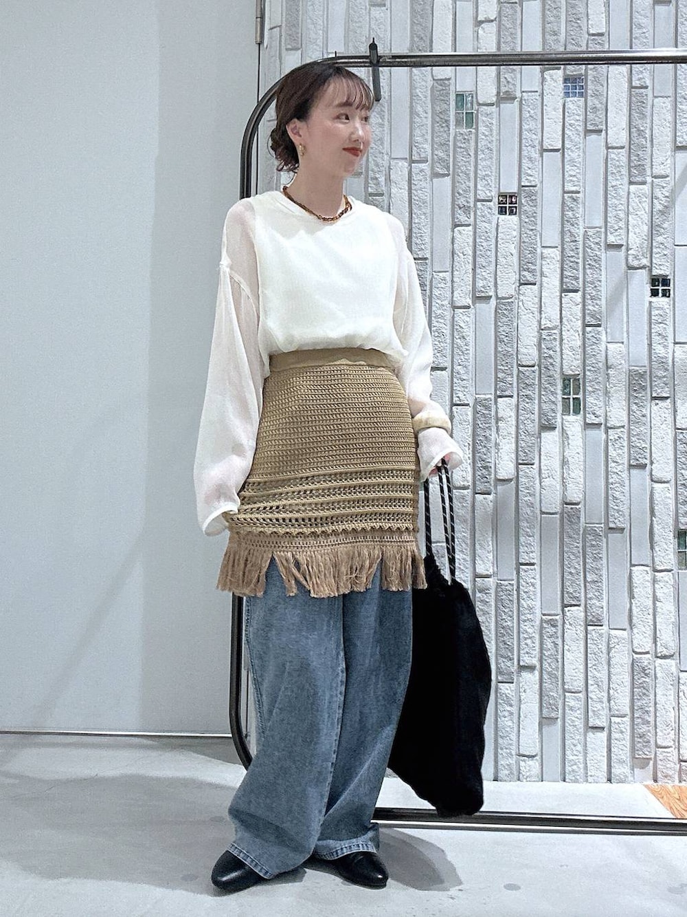 ブルー系のデニムパンツ、ブラック系のトートバッグ、ブラック系のパンプスを着用したレディースの春コーディネートの2枚目の写真