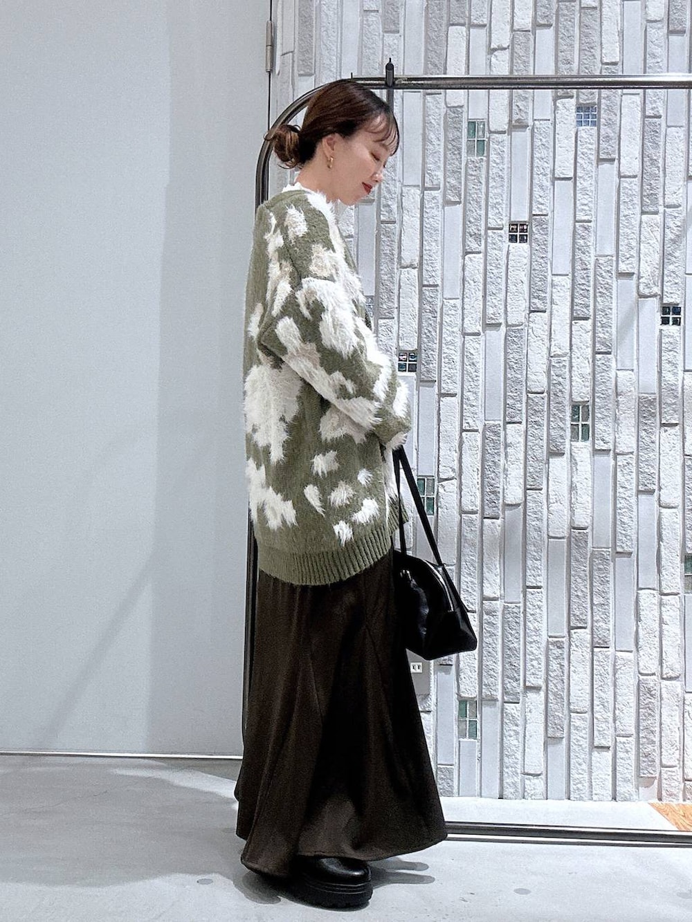 ホワイト系のニット/セーター、ブラック系のボストンバッグ、ブラック系のブーツを着用したレディースの冬コーディネートの3枚目の写真