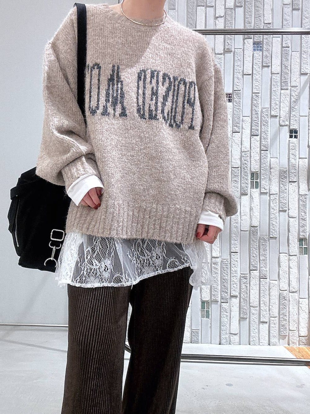 ホワイト系のTシャツ/カットソー、ベージュ系のニット/セーター、ブラック系のブーツを着用したレディースの冬コーディネートの5枚目の写真