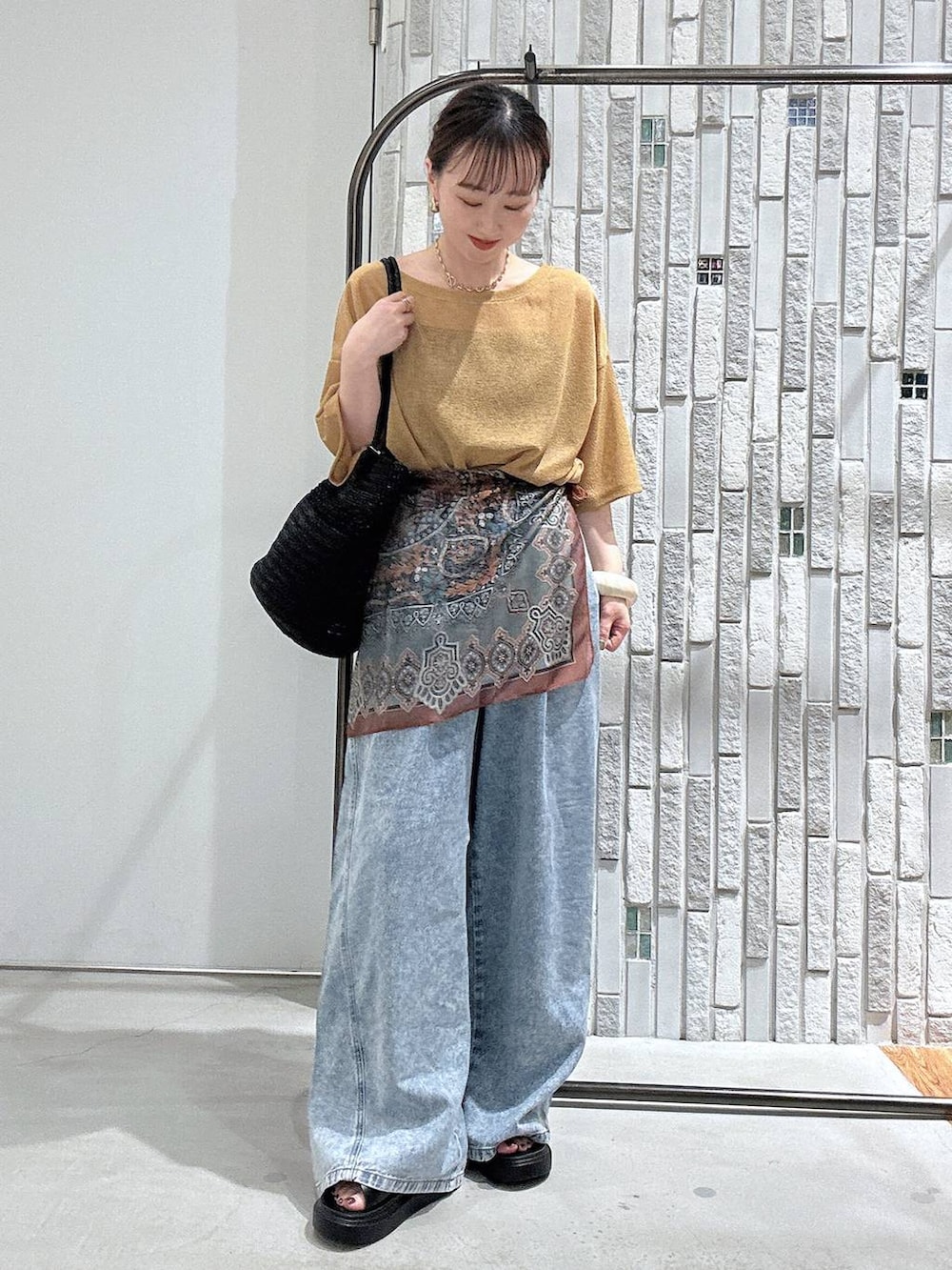 ブルー系のデニムパンツ、ブラック系のサンダル、グレー系のショルダーバッグを着用したレディースの春コーディネートの3枚目の写真