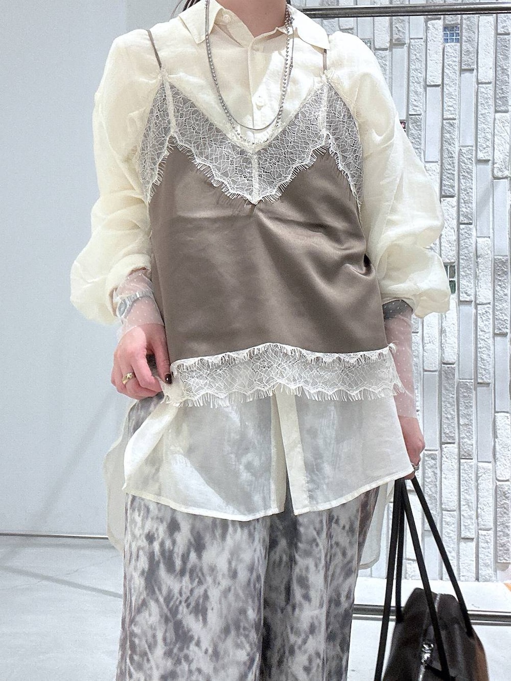 ホワイト系のシャツ/ブラウス、ホワイト系のTシャツ/カットソー、ブラウン系のボストンバッグを着用したレディースの春コーディネートの6枚目の写真