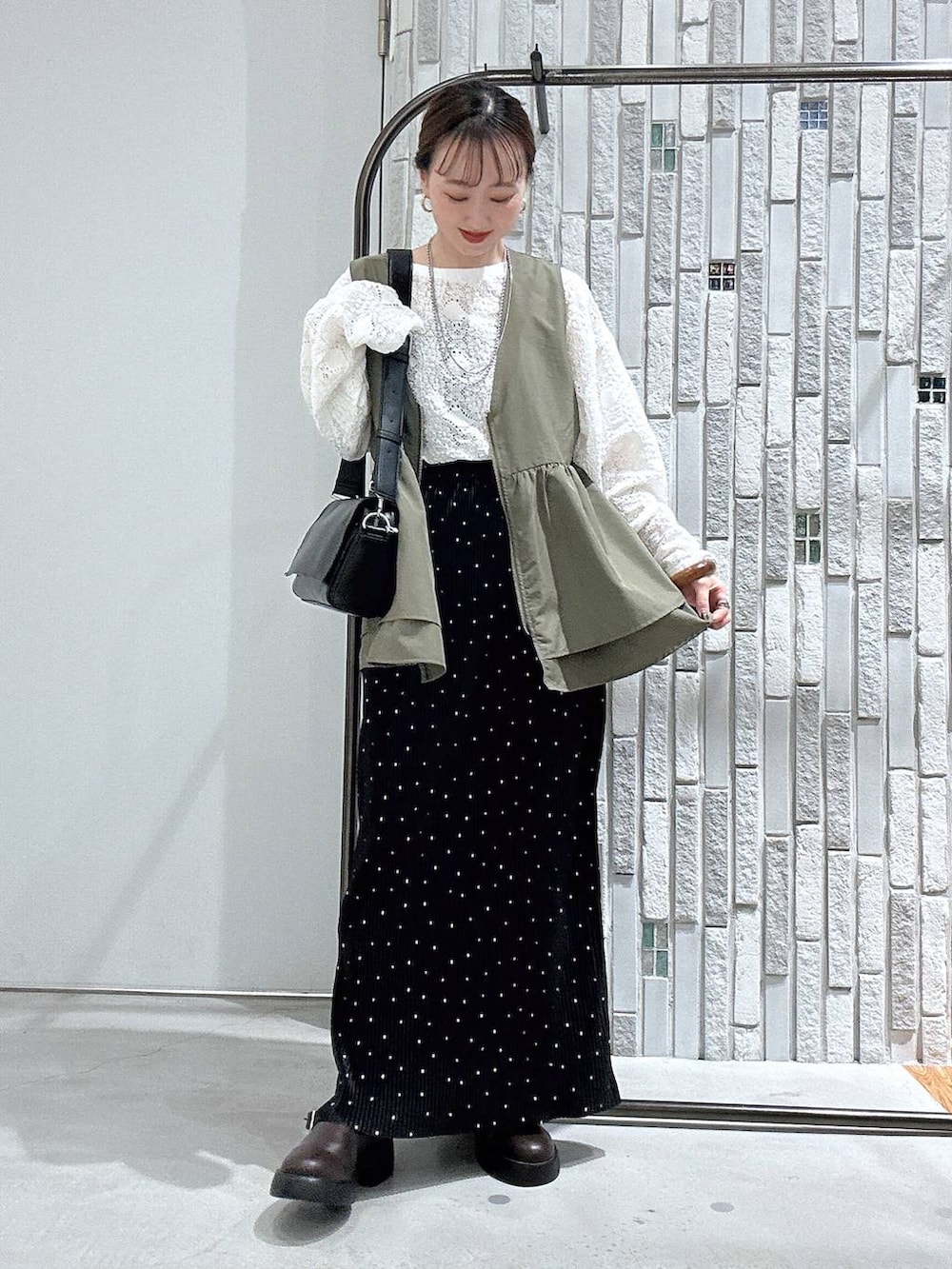 ブラック系のショルダーバッグ、ブラウン系のサンダル、ホワイト系のTシャツ/カットソーを着用したレディースの春コーディネートの6枚目の写真